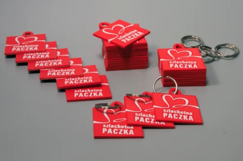Na zdjęciu breloczki wydrukowane w technologi 3d przez drukarnię 3dprodruk dla fundacji szlachetna paczka z logiem fundacji