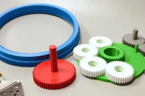 Kolorowe koła zębate i elementy wydrukowane w technologii druku 3D symbolizujące zrównoważoną produkcję